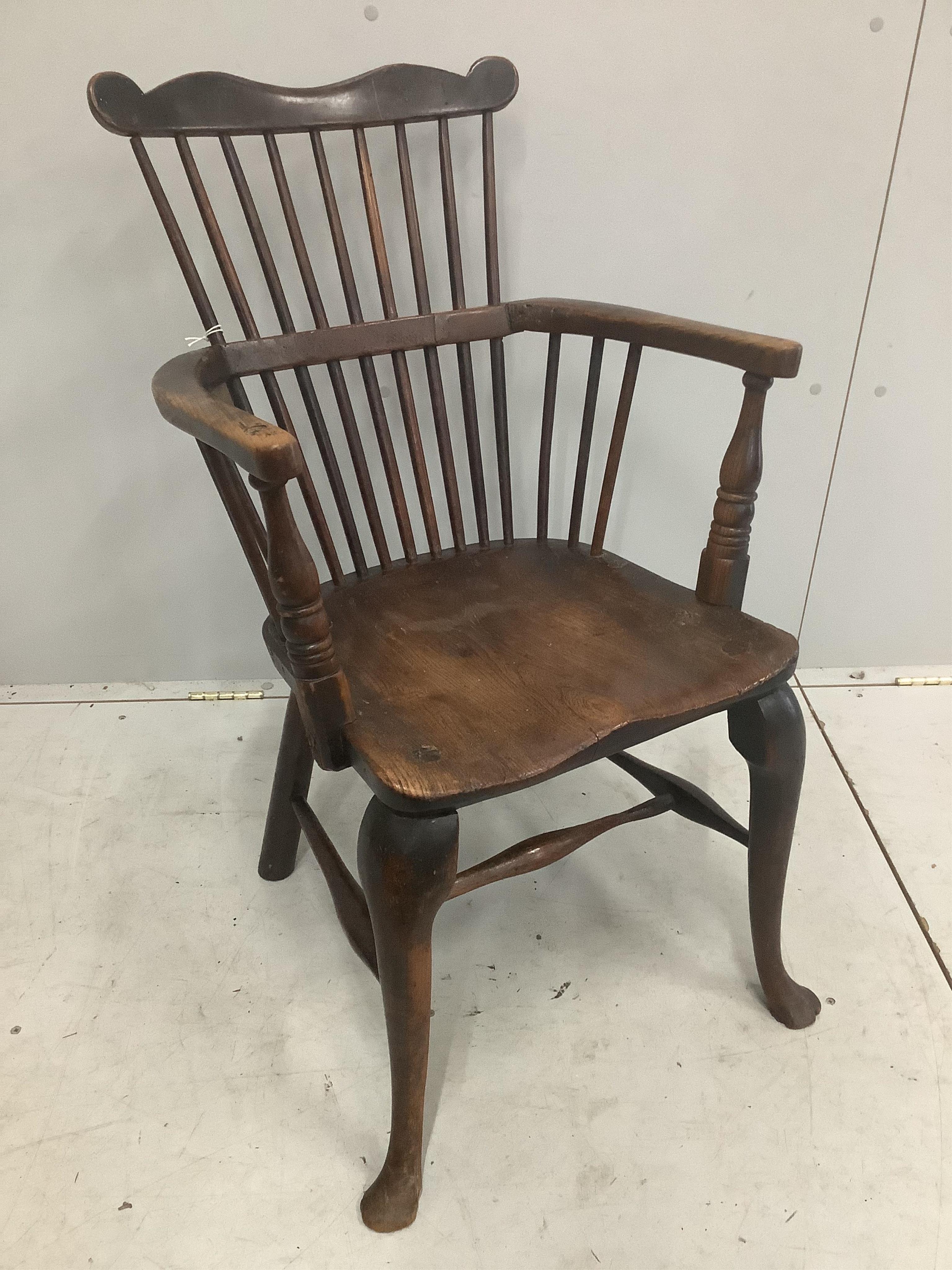 An early 18th century ash and elm primitive Windsor elbow chair on cabriole front legs, width 52cm, depth 43cm, height 89cm. Condition - fair